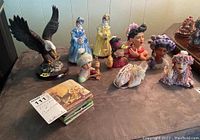 Group photo showing eagle figurine, five Cameo Girls vase figurines, two lady figurines, mini shoe and purse, and 7 coasters stacked