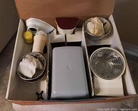 Full view of the Moulinex electric meat grinder with attachments arranged inside a cardboard box.