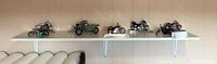 Five Harley Davidson motorcycle models displayed on a white shelf, different colors and styles, varying sizes