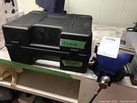 Black plastic Wagner carrying case, closed, dust and wear visible, measuring approximately 12x10x6 inches. Case has latch closures and built-in handle.