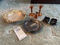 Overview of all items on carpet showing trays, bell, candlesticks and egg cups