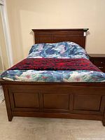 Front view of wooden double bed frame assembled with headboard, footboard, mattress and linens