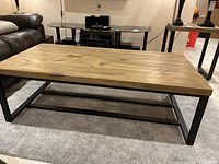Full side view showing rectangular wooden top and metal frame base with adjustable legs visible.