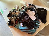 Photo showing the lot's cycling shoes, padded seat cover, jerseys, gloves, and lock grouped together on a table.