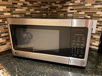 Full view of LG microwave with black and stainless steel finish on kitchen counter