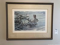 Full front view of framed Robert Bateman print with snowshoe hare in winter scene.