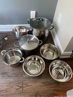 Full set showing two large pots (one with lid), one strainer insert, and five stainless steel bowls.