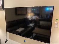 Front view of mounted TV showing screen and bezel reflection