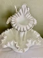 Top close-up view showing ruffled silver edge and white opaque glass with three vases connected to base.