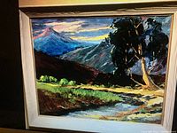 Frontal view of landscape oil painting on canvas framed in whitewashed wood with gold spacer