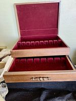 Front-on view of chest opened showing top tray with red velvet slots