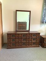Front view of large wood dresser with attached rectangular mirror against wall.