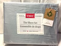 Front label of Endy sheet set packaging showing product name, Twin XL size, 300 thread count, 100% organic cotton, glacier blue color, and bilingual English/French text.