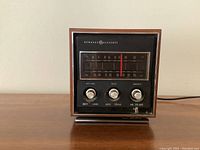 Front view of vintage General Electric radio, model T2280, showing the tuning window with visible frequency numbers and three round control knobs below