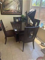 Dining table shown with chairs for scale but chairs excluded from lot. Dark wood polished surface and sturdy pedestal base visible.