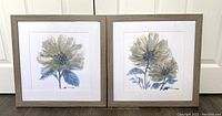 Two floral watercolor paintings side by side in matching light wood frames