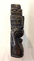Front view of the signed wooden carved totem showing detailed animal forms and geometric shapes typical of native art.