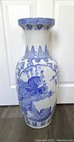 Front view of vintage blue and white Chinese floor vase with bird and floral designs.