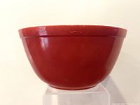 Side view of vintage Pyrex bowl showing solid deep red burgundy exterior color