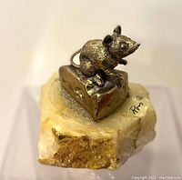 Side angle of the bronze mouse figurine on cheese atop onyx base, showing artist's signature
