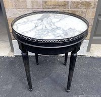 Front angled view of the vintage round side table showing marble top and tapered legs.