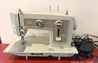 Front and side views of the vintage Sears Kenmore sewing machine showing the manual controls, needle area, and power cord with attached foot pedal.
