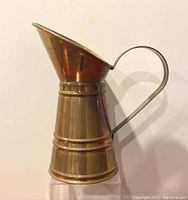 Side view of copper pitcher vase showing height and angled spout