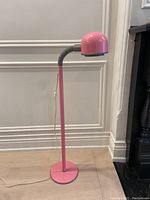 Full view of the pink and grey floor lamp standing upright, showing its overall shape and design.