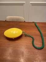 Lamp placed on wooden table with coiled green cable spread out.