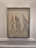 Full view of framed artwork showing stylized figures printed on glass and paper in chrome shadow box frame.