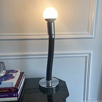 Lamp illuminated with bulb inserted, showing its height and design