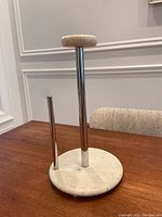 Full view of paper towel holder on table showing marble base, chrome rods, and marble top cap.
