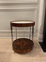 Front view of round two-tier serving table with rosewood veneer and chrome legs