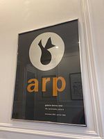 Framed Jean Arp serigraph poster in chrome frame hanging on wall