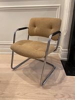 Front angle view of the vintage Steelcase cantilever chair showing chrome frame and tan wool upholstery.