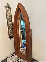 Full front view of pointed-arch pine frame with mirror reflecting interior.