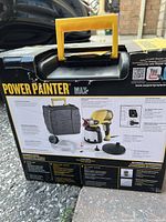 Photo of the back of the box with technical details, carrying case, and paint sprayer image