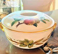 Side view of Royal Worcester serving dish with lid, showing apple and hop fruit pattern, gold handles, and gold trim on white porcelain.