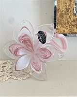 Front view of the handcrafted Murano glass flower sculpture showing the translucent petals with pink and white swirls and the Murano authenticity sticker.