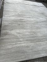 Full view of rug laid on pavement showing overall pattern and dimensions