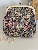 Front view of vintage French tapestry handbag showing detailed classical motif with two figures and floral design