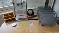 Overview of all items on desk including desk clock, file organizers, wooden organizer and calendar