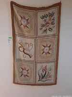 Full front view of the hooked rug hanging on the wall, showing all six panels and the color scheme.