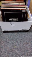 Banker's box partly filled with LP vinyl records, showing the 'The Soul King Otis Redding: A Tribute' LP in front.