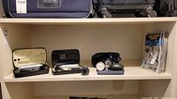 Photo of two stethoscope sets in zippered cases on shelf with blood pressure tester