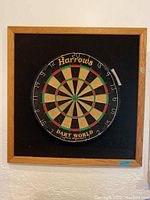 Front view of the Harrows Dart World dartboard mounted on a wooden frame with black felt.