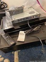 Sony and Philips electronics including Blu-ray players and amplifier arranged together, with a remote and cables visible.