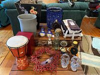 Shot showing numerous assorted home decor items including ceramics, glassware, textile, candle holders, and drum.