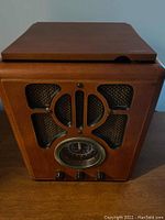 Front view of the wooden cabinet with patterned speaker grille and radio dial.