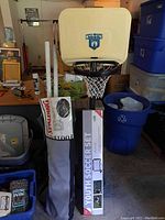Photo showing the child's plastic basketball hoop with Celtics logo, youth soccer set poles in bag, and surrounding items